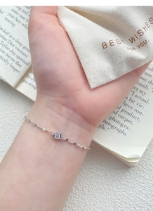 Detail of S925 sterling silver chain bracelet with a sparkling round zircon on a wrist