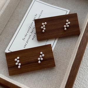 Élégantes boucles d'oreilles en argent S925 et perles sur support en bois vintage