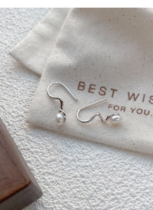 Detailed close-up of S925 silver wavy ear hooks with elegant natural freshwater pearls