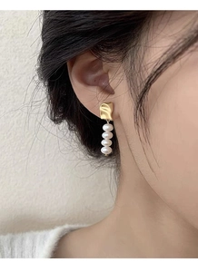 Close-up of S925 silver baroque freshwater pearl earrings on model for elegant style