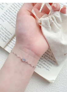 Macro view of minimalist S925 sterling silver bracelet with a single sparkling zircon stone