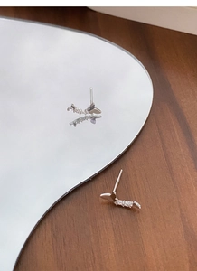 Gros plan de boucles d'oreilles papillon en argent 999 avec zircons sur miroir