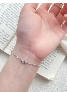 Close-up of S925 sterling silver chain bracelet with a single sparkling zircon on hand