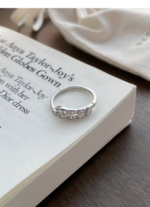 Detail of S925 sterling silver snake ring with cubic zirconia inlay on a white book