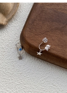 Detail of S925 silver asymmetric star and moon clip earrings with blue and white stones