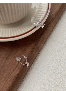 Detail of S925 silver star and moon earrings with blue zircon in a lifestyle setting