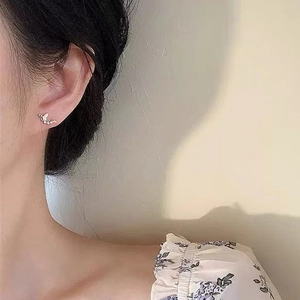 Boucles d'oreilles papillon en argent avec zircons portées par un mannequin femme