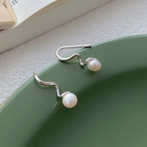 Minimalist S925 sterling silver spiral earrings with fresh water pearls on a ceramic dish