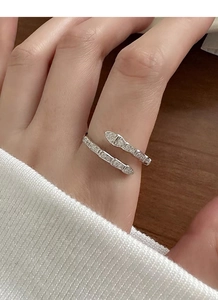 Close-up of S925 sterling silver snake ring with pavé diamonds on woman's finger