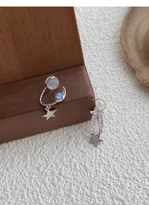 Detailed close-up of S925 silver star and moon earrings with blue gemstones and chains