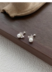 Detailed macro of 999 sterling silver butterfly bow earrings with white round pearls