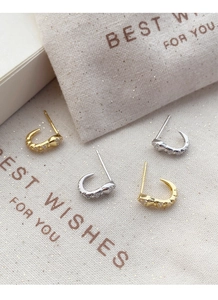 Detailed close-up of S925 sterling silver snake stud earrings in gold and silver plating