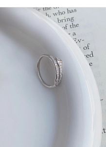 Macro detail of S925 sterling silver snake ring with sparkling zircon inlays on white ceramic