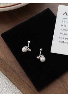 Detail shot of silver butterfly pearl stud earrings with secure ball screw backs on velvet