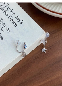 Detailed shot of S925 silver star and moon earrings with blue gemstones on a white page