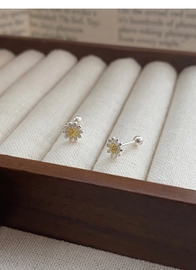 Detail von S925 Sterling Silber Gänseblümchen-Ohrringen mit gelber Mitte auf einer Schmuckbox