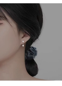 Detail of S925 sterling silver star stud earring with cubic zirconia on model's ear