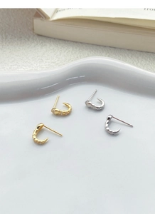 Detailed macro view of S925 silver snake stud earrings in gold and silver plating