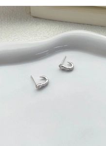 Detailed close-up of S925 silver snake stud earrings with shimmering white zircon stones
