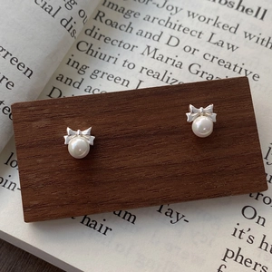 Elegant 999 sterling silver butterfly pearl screw back earrings on vintage book background