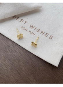 Macro detail of S925 sterling silver four-leaf clover stud with radiant engraved texture