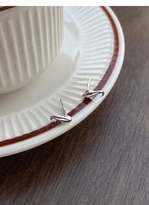 Makro-Detail von S925 Sterling Silber Delphin-Ohrsteckern mit Punzierung auf Keramikrand