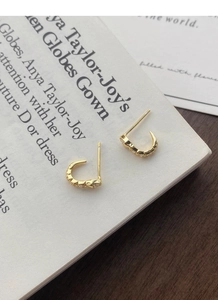 Detail of S925 silver snake stud earrings with sparkling crystals and gold plating