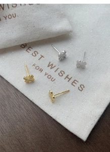 Detail of clover earrings in gold and silver showing S925 hallmark and textured finish