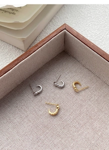 Detail view of gold and silver S925 sterling silver snake earrings with tiny crystals