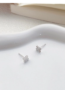 Detailed close-up of S925 sterling silver four-leaf clover stud earrings with sunburst texture