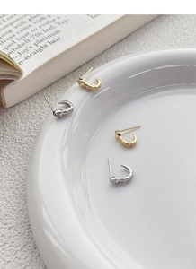 Macro view of gold and silver S925 sterling silver snake stud earrings with zircon