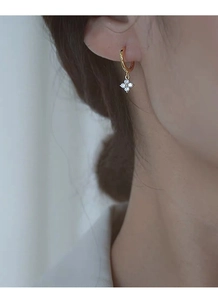 Détail de boucles d'oreilles trèfle en argent S925 doré avec zircons sur le mannequin