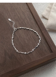 Detailed macro shot of S925 sterling silver rose and leaf links on dark wood background