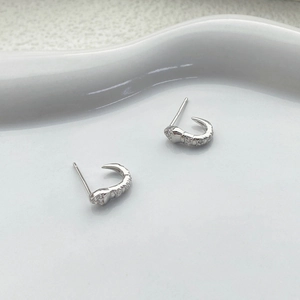 S925 sterling silver snake stud earrings with zircons on white ceramic tray