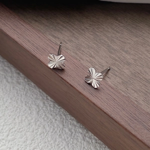 Minimalist S999 sterling silver four-leaf clover stud earrings with radiant faceted finish