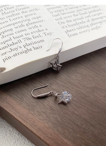 Détail macro de boucles d'oreilles étoile en argent avec pierre zircone claire