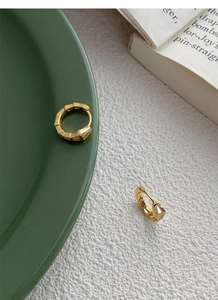 Vue détaillée de boucles d'oreilles huggie géométriques dorées avec incrustation zircon