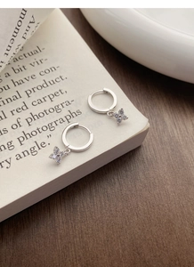 Vue détaillée des boucles d'oreilles trèfle en argent S925 avec zircons scintillants