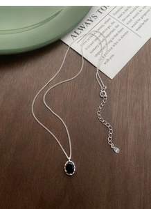 Macro shot of S925 sterling silver stamp on oval black zircon necklace pendant