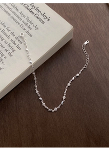 Macro shot of S925 sterling silver rose and leaf bracelet on vintage book page background