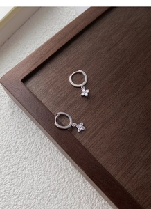 Gros plan de boucles d'oreilles fleur en argent S925 et zircons sur plateau