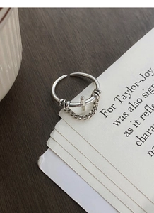Close-up of vintage S925 silver ring featuring a cross pendant and delicate chain detail