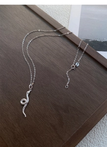 Makroaufnahme der S999 Silber Schlangenkette mit realistischer Textur und grünen Augen Details