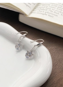 Vue détaillée de boucles d'oreilles étoile en argent avec zircon sur une assiette