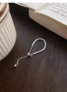 Close-up of S925 sterling silver adjustable chain ring on a dark wooden surface
