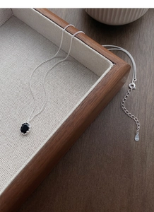 Close-up of S925 sterling silver necklace with oval black zircon pendant in claw setting