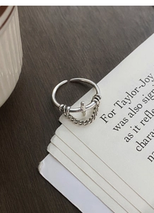 Close-up of S925 sterling silver cross ring with chain pendant on vintage wood background