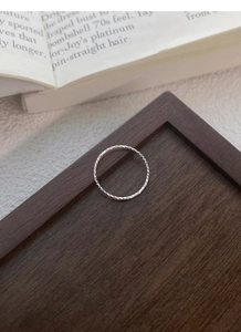 Detailed shot of S925 sterling silver textured ring on a premium wooden display stand
