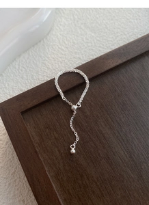 Detail of S925 sterling silver chain ring featuring a polished ball tassel pendant