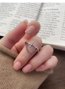 Close-up of S925 sterling silver ring featuring a cross pattern and hanging chain detail